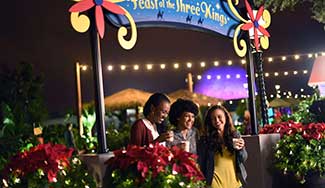 Three younf women drinking egg nog surrounded by poinsettia