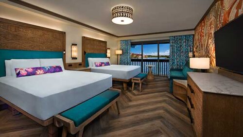View of a Polyneisan room showing two queen beds and a balcony