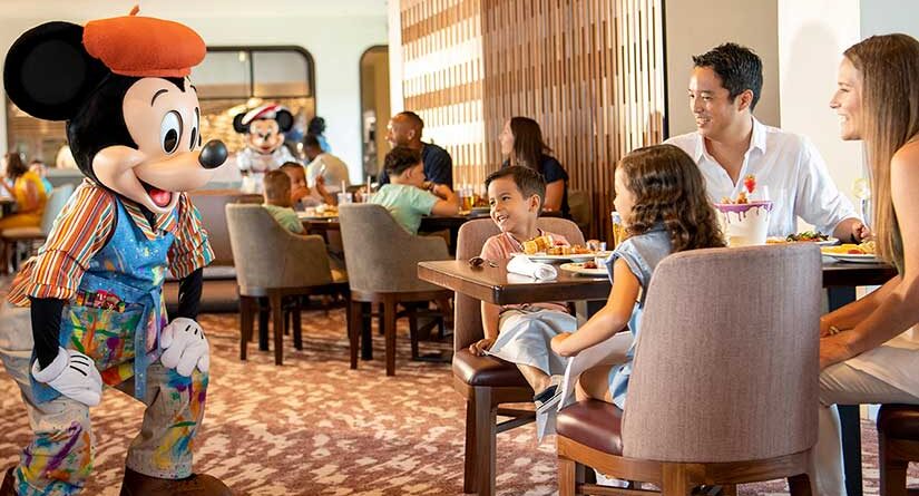 Mickey Mouse greeting guests table side at Topolino's restaurant at Disney's Riviera resort