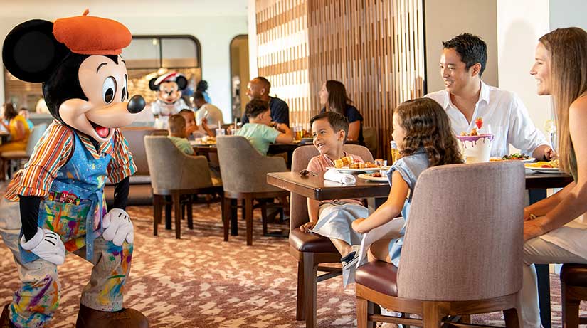 Mickey Mouse greeting guests table side at Topolino's restaurant at Disney's Riviera resort